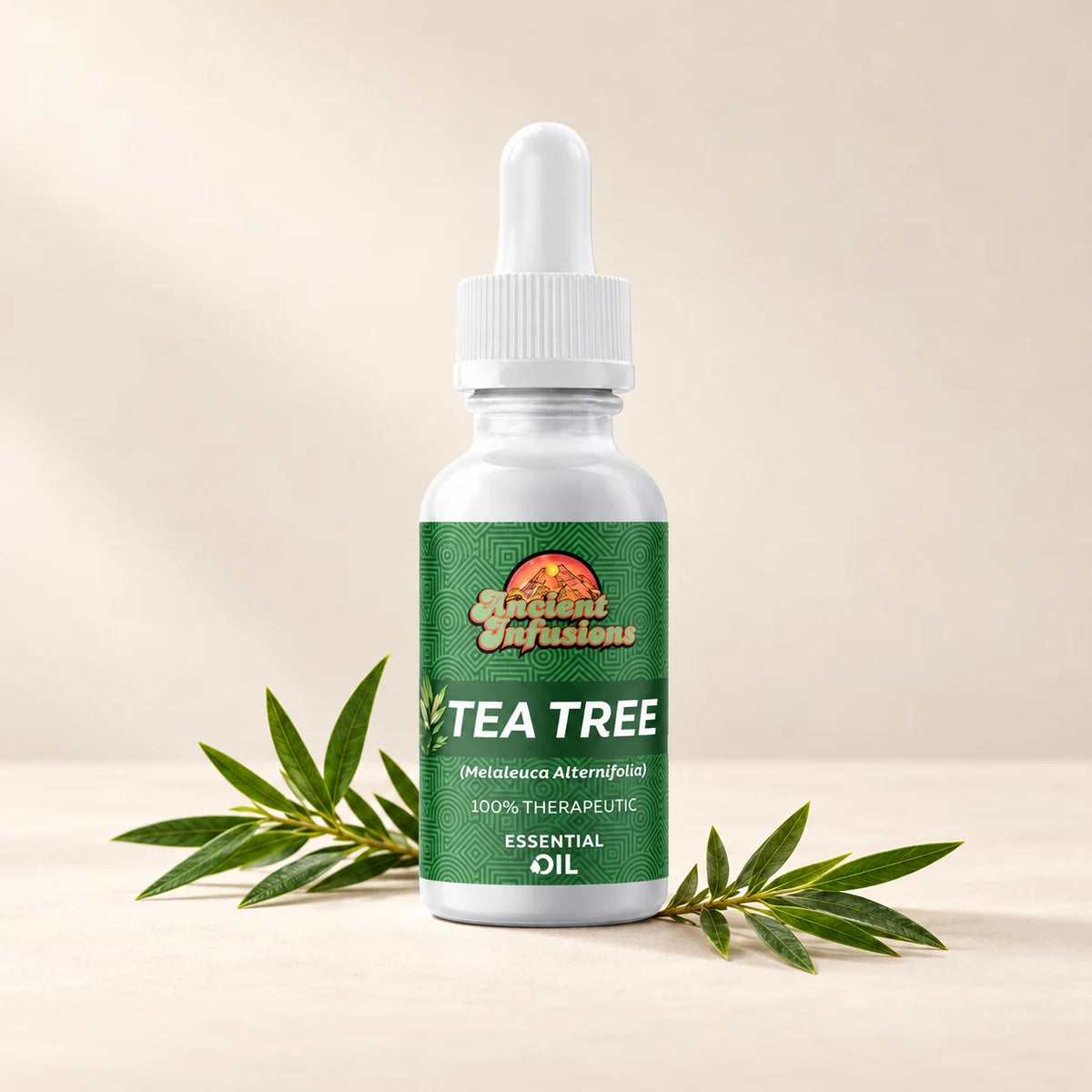 Ancient Infusions Tea Tree Essential Oil bottle with botanicals on a soft ivory background.
