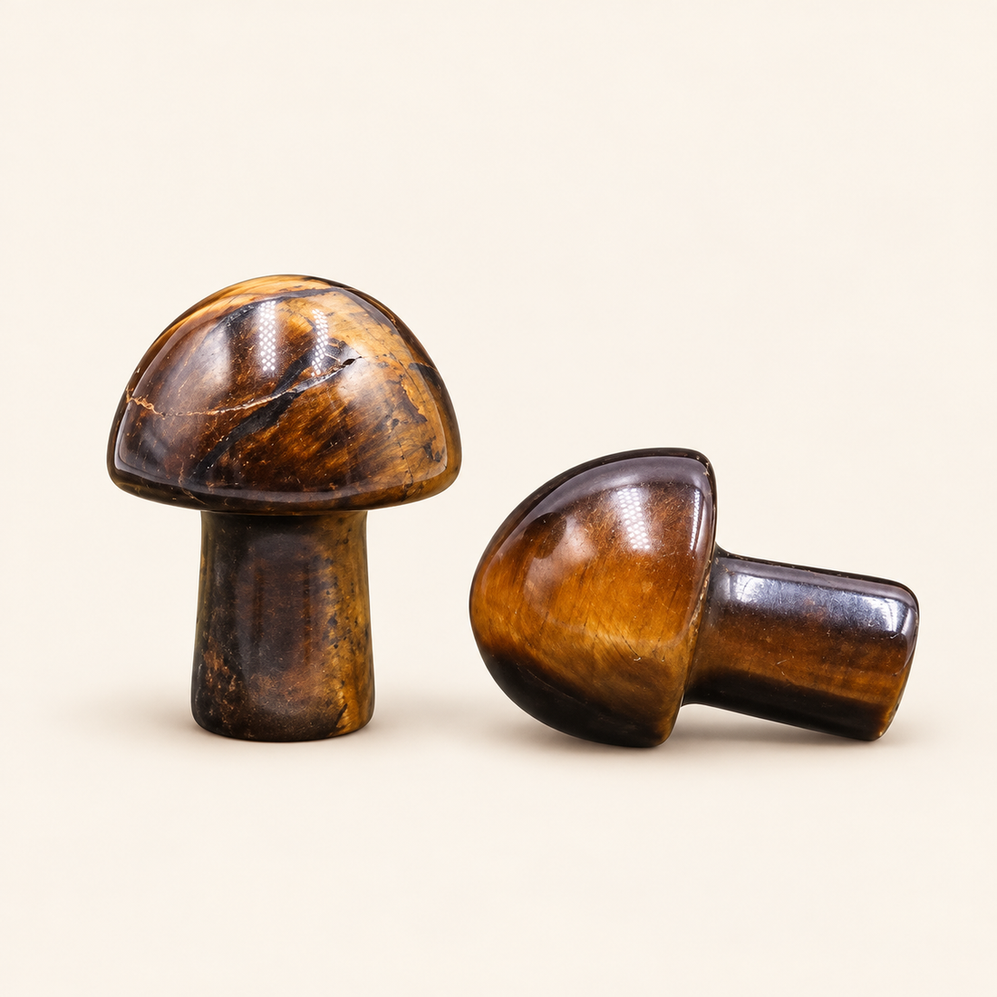 Tiger's Eye Carved Mushroom with golden-brown bands and a reflective sheen on a soft ivory background