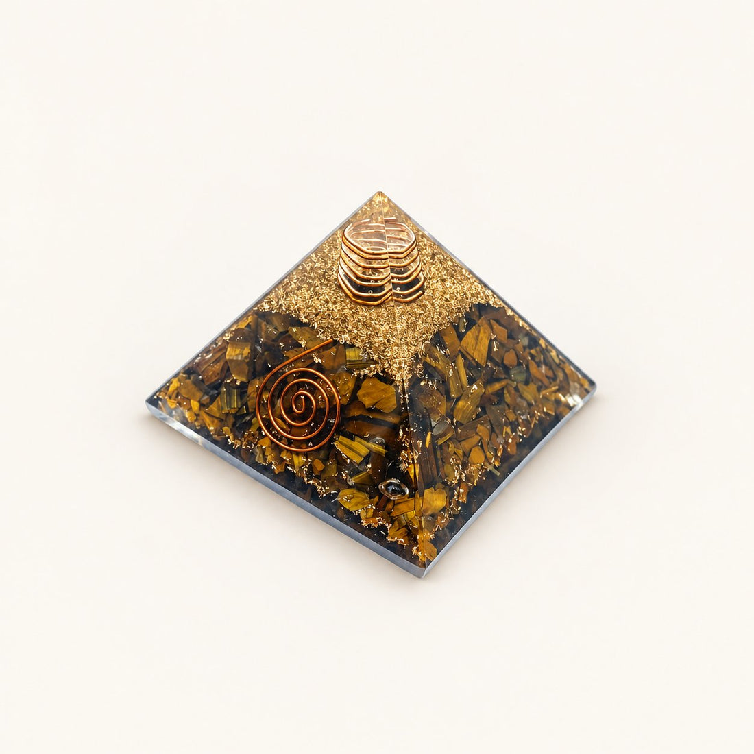 Tiger’s Eye Orgone Pyramid with golden-brown tiger’s eye chips and metallic details on a warm ivory background