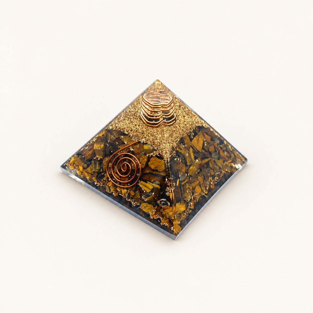 Tiger’s Eye Orgone Pyramid with golden-brown tiger’s eye chips and metallic details on a warm ivory background