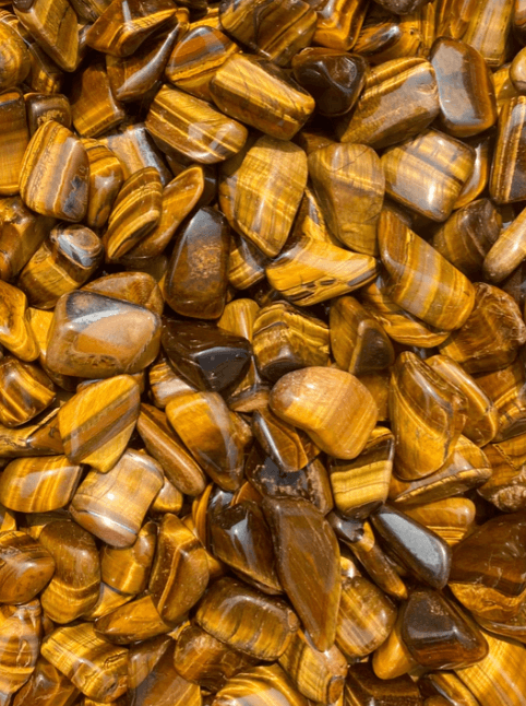 Polished Tiger’s Eye tumbled stones showcasing their golden hues, healing properties, and grounding benefits.