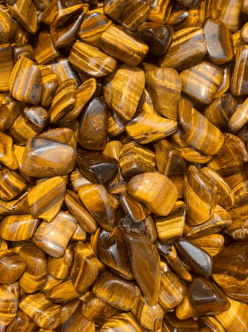 Polished Tiger’s Eye tumbled stones showcasing their golden hues, healing properties, and grounding benefits.