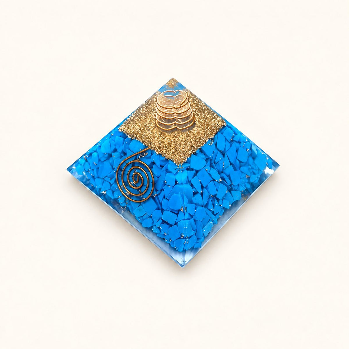 Turquoise Orgone Pyramid with bright blue turquoise chips and metallic details on a warm ivory background