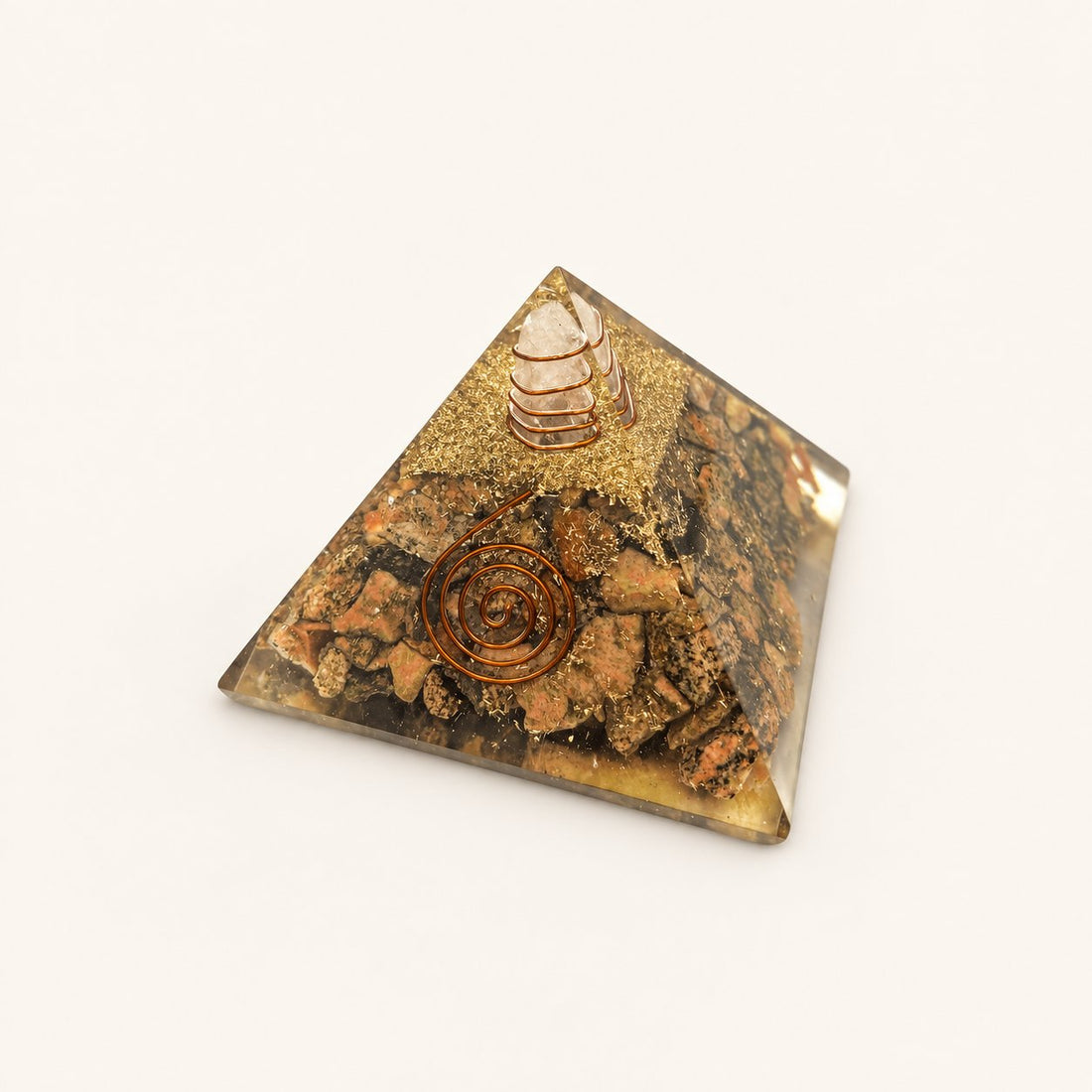 Unakite Orgone Pyramid with earthy green and pink unakite chips and metallic details on a warm ivory background